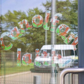 sticer canolfan iaith ar ffenest