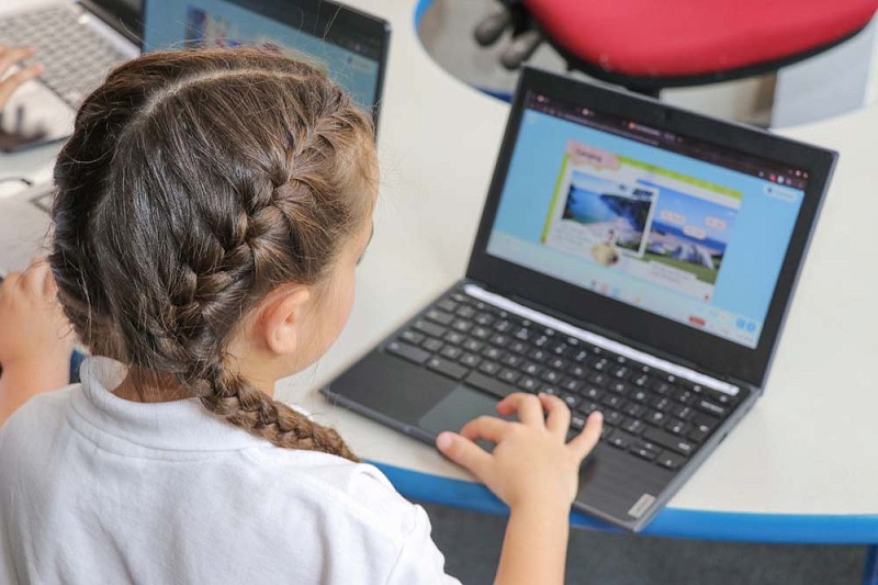 myfyriwr yn gweithio ar ei gliniadur yn y dosbarth