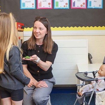 athro a myfyriwr yn chwarae yn y tŷ chwarae